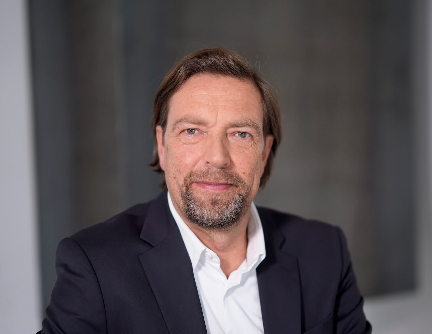 Porträt Bild von Joachim Spiering, Leiter der Presse- und Öffentlichkeitsarbeit, auf grauem Hintergrund